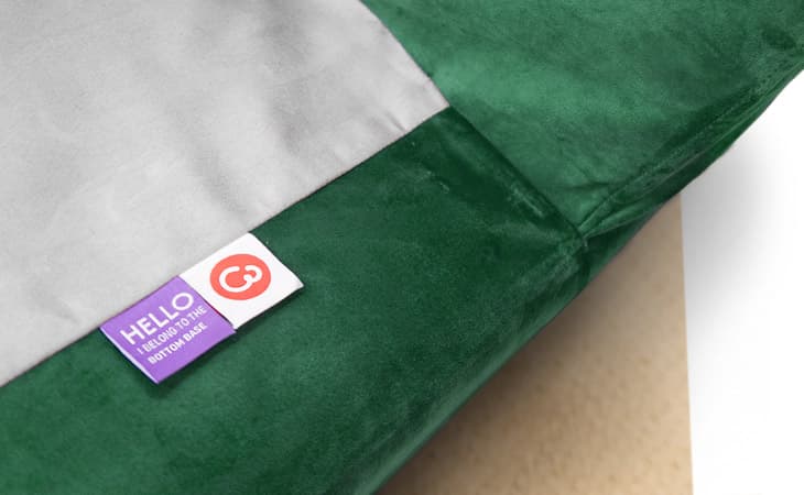 Close-up of custom sofa cover labels, made by Comfort Works in green velvet (Rouge Emerald).